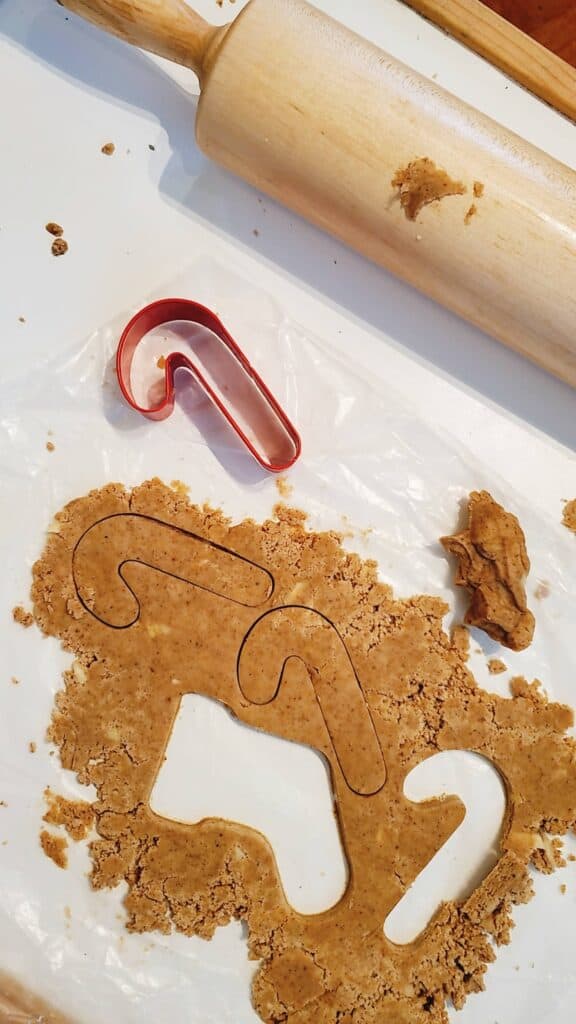 Rolling out gluten free Christmas speculaas cookies needs to be done carefully, and between sheets of parchment paper.